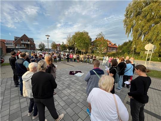 Rund 60 Frauen und Männer haben am Donnerstagabend am Burgmannshof eine Gedenkminute für die am Mittwoch vergangener Woche in der Moorstraße in Horneburg von ihrem Noch-Ehemann getötete Renata S. (47) eingelegt. Fotos: Vasel