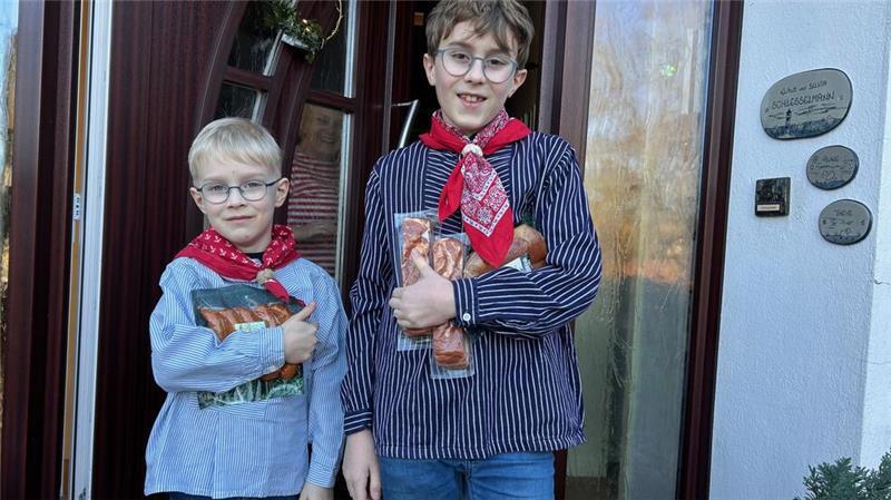 Rune und Theve Schlesselmann überreichen die Speck-Spende stilecht in Fischerhemden.