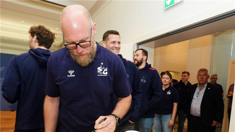 Wem Handball-Fan Günther die Daumen drückt SG-Trainer Ales Pajovic trägt sich in das Gästebuch der Landesregierung von Schleswig-Holstein ein.
