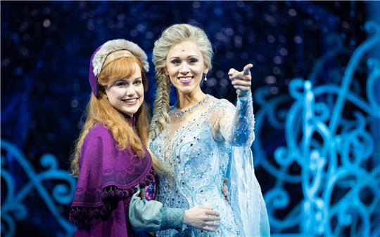 Sabrina Weckerlin (Eiskönigin Elsa, r) und Celena Pieper (ihre Schwester Anna), Musicaldarstellerinnen in dem neuen Musical "Die Eiskönigin". Foto: Christian Charisius/dpa