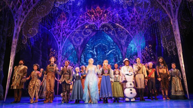 Disney-Musical „Die Eiskönigin“ feiert 1000. Aufführung Sabrina Weckerlin (als Eiskönigin Elsa, Mitte, links), Celena Pieper (als Anna, die Schwester der Eiskönigin, Mitte, rechts), und weitere Musicaldarsteller stehen auf der Bühne im Stage Theater an der Elbe.