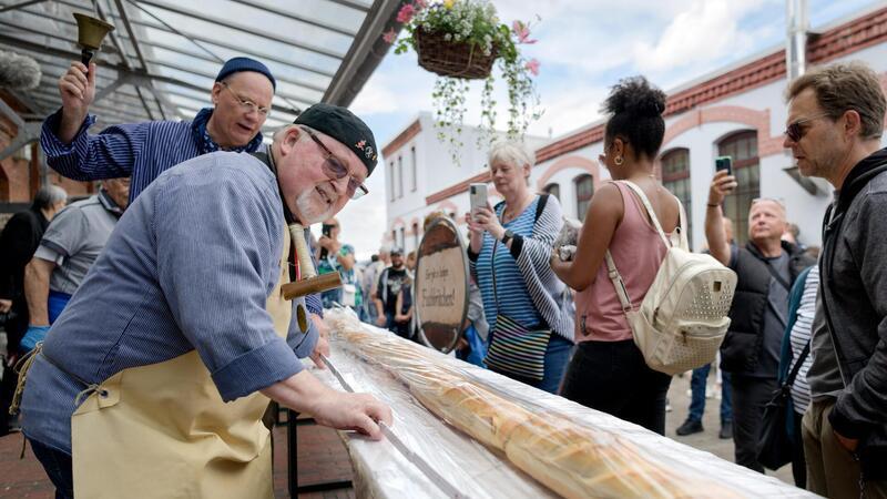"Salzer" Gerd Blancke überprüft gewissenhaft die ordnungsgemäße Länge des erstmals 32 Meter langen Matjesbrötchens. 