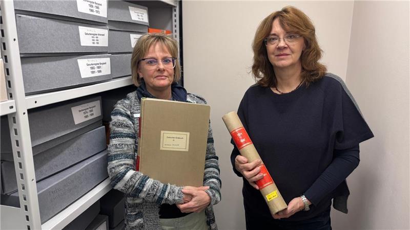 Samtgemeindearchivarin Ulrike Gerdts (links) und Mitarbeiterin Jenny von Rönn mit den Standesamtregistern. Ihr persönlich größter Archivschatz findet sich im Sterberegister 1874 wieder.