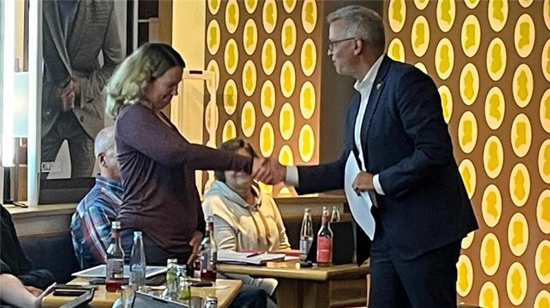 Samtgemeindebürgermeister Knut Willenbockel begrüßt Fenja Beckedorf im Kaufhaus Mohr am 18. September 2024 offiziell als neues Ratsmitglied.