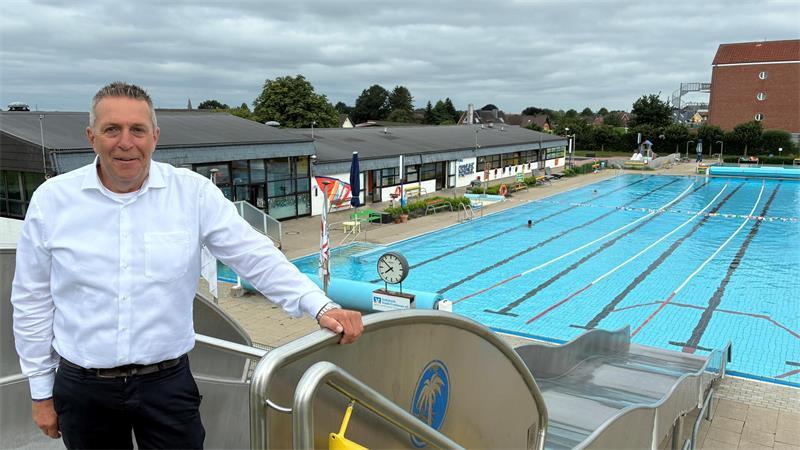 Samtgemeindebürgermeister Timo Gerke steht auf der Rutsche im Freibad in Twielenfleth. Das Technik-, Sanitär- und Umkleidegebäude von 1974 ist sanierungsbedürftig.