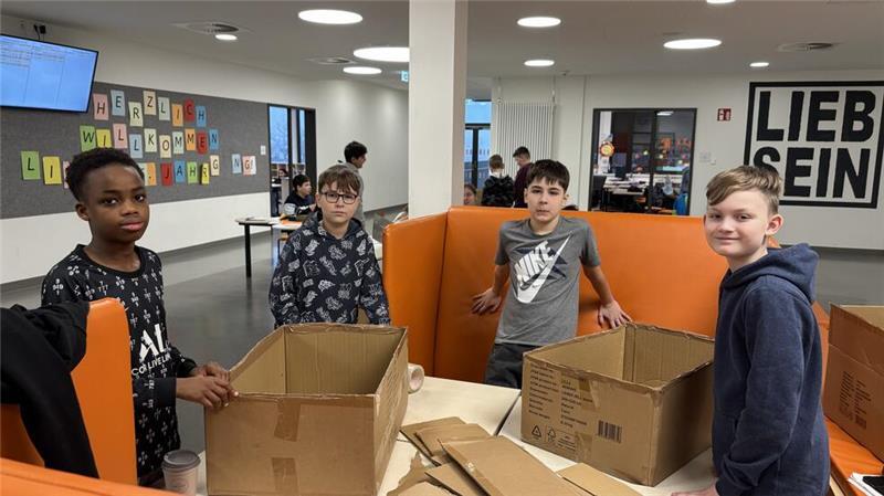 Samuel (v. li.), Adrian, Elias und Nick arbeiten im Gemeinschaftsbereich an einem Projekt.