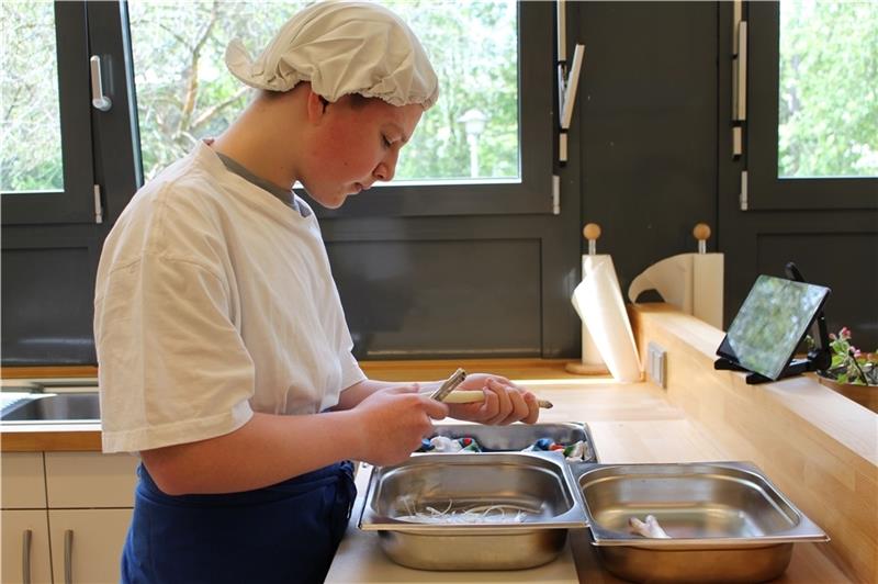 Sandro Puls übt in der Küche der BBS das Spargelschälen. Foto: Frank