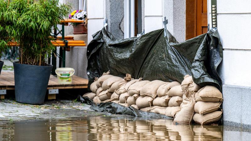 Expertenrat plädiert für Pflichtversicherung für Elementarschäden Sandsäcke liegen vor einem Haus. In Bayern herrscht nach heftigen Regenfällen vielerorts weiter Land unter.