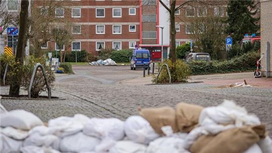 Sandsäcke liegen vor einem evakuierten Wohnhaus.