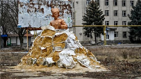Sandsäcke schützen ein Denkmal des aus Huljajpole stammenden ukrainischen anarchistischen Revolutionärs Nestor Machno. 