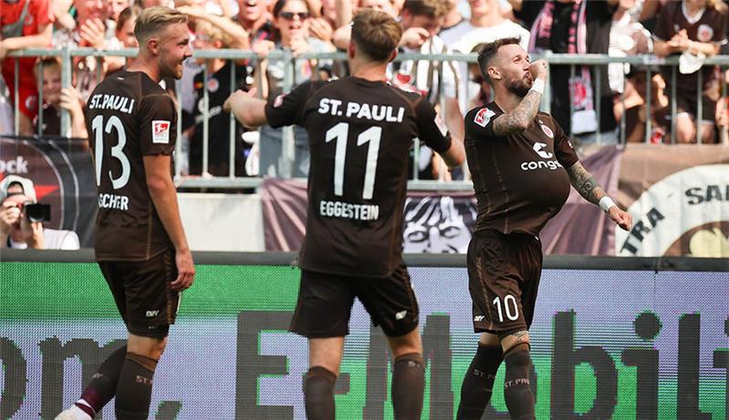 Sankt Paulis Marcel Hartel (r) feiert sein Tor zum 3:0 mit Johannes Eggestein und Lukas Daschner (l). Foto: Christian Charisius/dpa