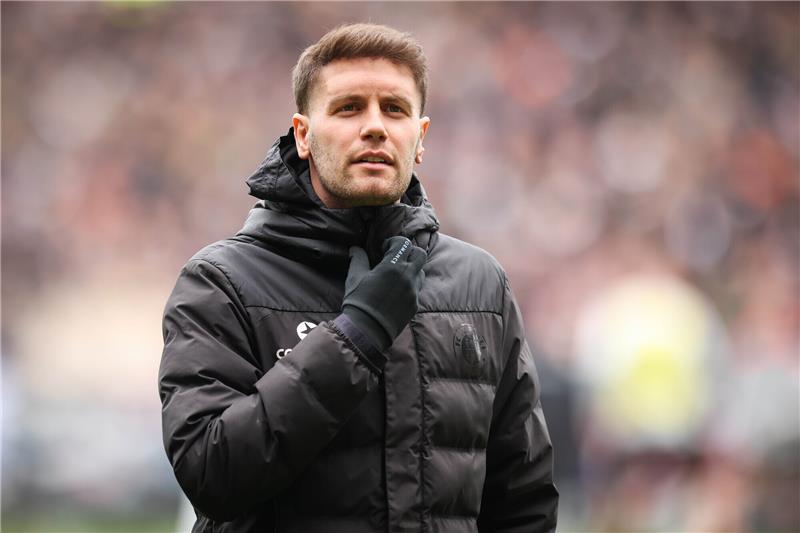 Sankt Paulis Trainer Fabian Hürzeler geht vor dem Spiel über den Platz. Foto: Christian Charisius/dpa