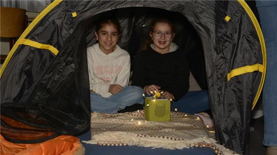 Sarah Armit und Adelina Schmidke (5G1) machen es sich beim Lesefest in einem der kleinen Zelte mit einem Hörspiel gemütlich.