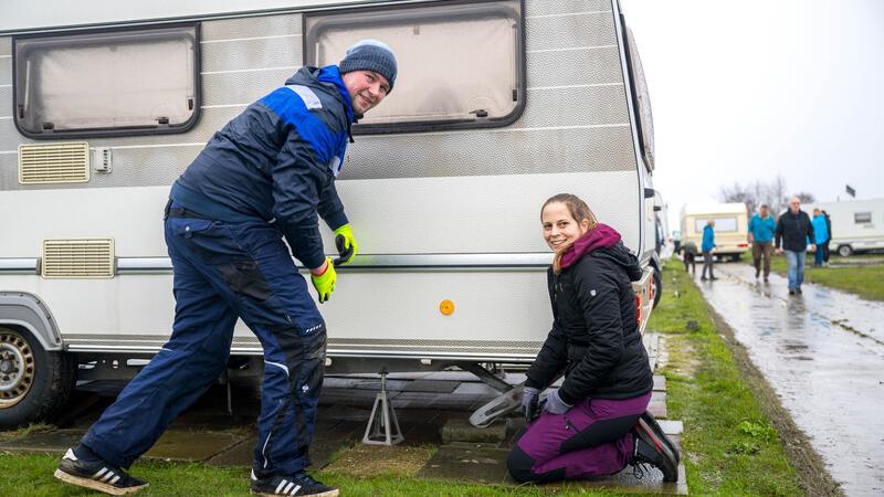 Sascha Stroick und Carina Erdmann stellen ihren Wohnwagen auf dem Campingplatz auf.