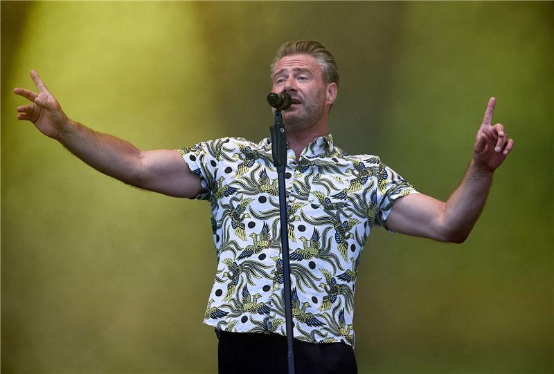 Stehkonzert nicht zugelassen – Sasha-Konzert in Stade erneut verschoben Sasha, Sänger, steht auf der Bühne des Strandkorb Open Air-Konzerts am Cruise Center Steinwerder. Foto: Georg Wendt/dpa