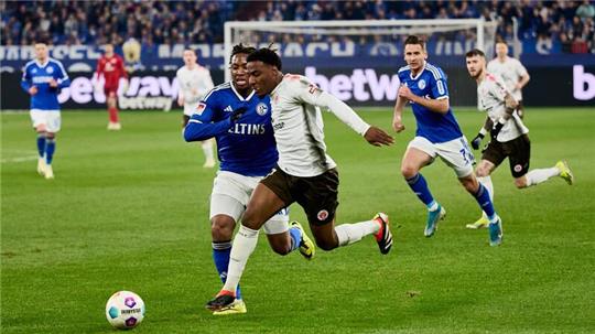 Schalkes Brandon Soppy (r) und Oladapo Afolayan (2.v.r) von St. Pauli in Aktion.