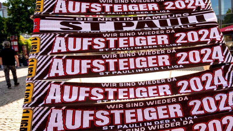 Demo und Party: St. Pauli mit Details zur Aufstiegsfeier Schals mit der Aufschrift „Aufsteiger 2024“ werden auf der Reeperbahn verkauft.
