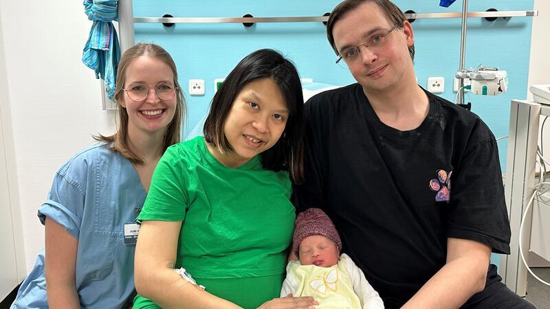 Schaltjahr-Baby Mina mit ihren Eltern Suapha und Yannick aus Buxtehude und der betreuenden Hebamme Nele-Marie Schreiber.