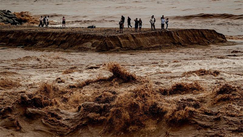 Mindestens drei Tote bei schweren Unwettern in Spanien Schaulustige beobachten das aufgewühlte Wasser an der Mündung des Flusses Besòs nördlich von Barcelona.