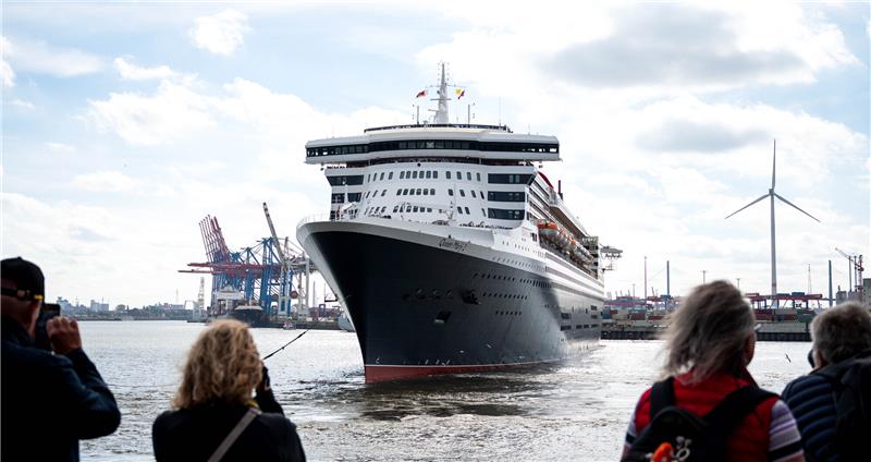 Schaulustige beobachten, wie das Kreuzfahrtschiff „Queen Mary 2“  in den Hamburger Hafen einläuft. Foto: Daniel Bockwoldt/dpa/Daniel Bockwoldt