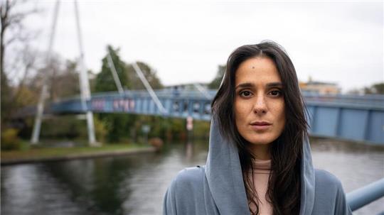 Schauspielerin Aybi Era - im Hintergrund der Tatort ihres neuen Falles.