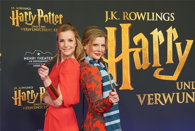 Schauspielerin Kim-Sarah Brandts (l) und Schauspielerin Eva Habermann gehen über den roten Teppich zur Premiere der neu inszenierten Show "Harry Potter und das verwunschene Kind“ im Mehr! Theater am Großmarkt. Foto: Marcus Brandt/dpa