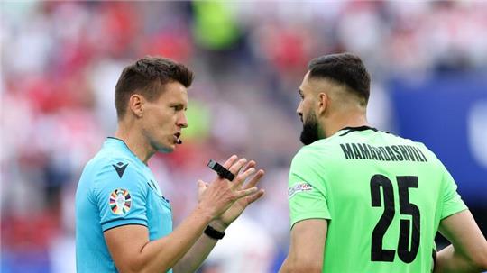 Schiedsrichter Daniel Siebert aus Deutschland (l) spricht mit Georgiens Torhüter Giorgi Mamardaschwili.