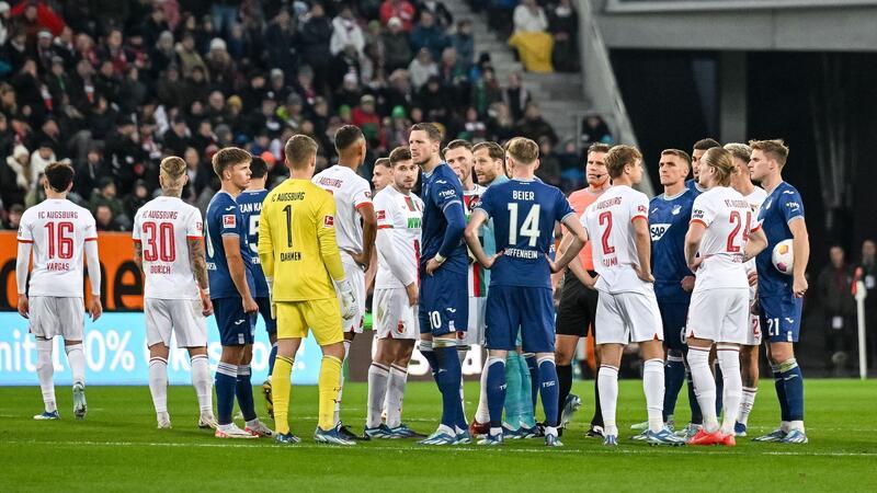 Schiedsrichter Felix Brych bespricht sich mit den Spielern am Mittelkreis.