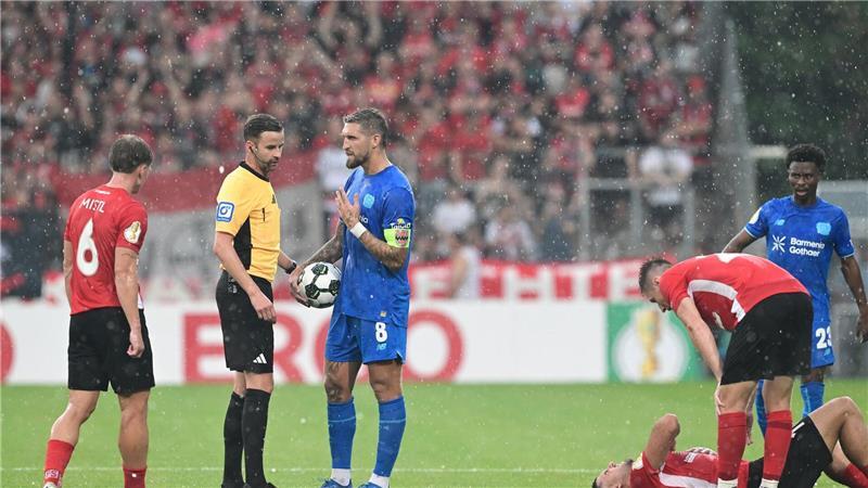 DFB-Pokal: Drei Kleine raus - Leverkusen weiter Schiedsrichter Michael Bacher (2.v.l.) muss das Spiel in Großaspach unterbrechen