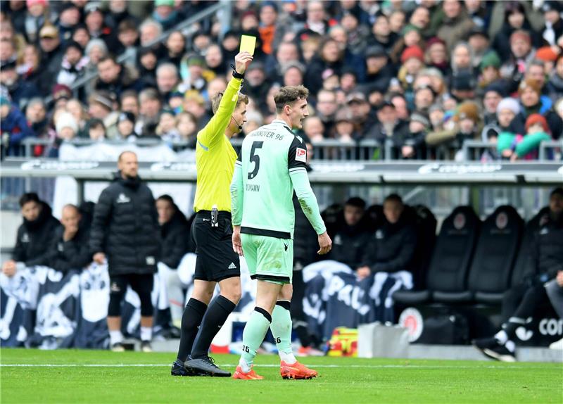 Hürzeler-Premiere und Debatte um VAR: St. Pauli siegt gegen Hannover 96 Schiedsrichter Timo Gerach (l) zeigt Hannovers Phil Neumann die gelbe Karte. Foto: Michael Schwartz/dpa