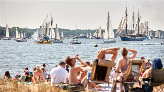 Schiffe, Boote, Segler und Traditionssegler nehmen an der Windjammerparade der Kieler Woche auf der Förde teil.