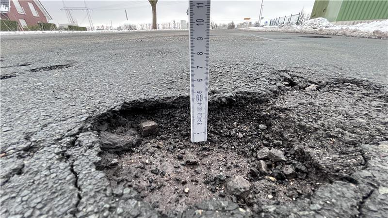 Schlagloch auf der K32 (Bassenflether Chaussee): Im Hintergrund ist das AKW Stade zu sehen.