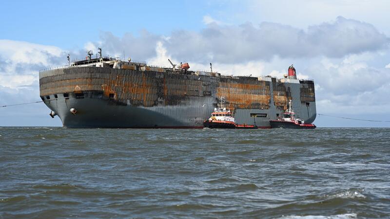100 Tage nach Brand: „Fremantle Highway“-Zukunft ungewiss Schlepper begleiten den schwer beschädigten Autofrachter “Fremantle Highway„ in den Hafen.