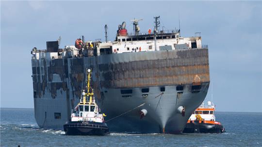 Schlepper ziehen den schwer beschädigten Autofrachter »Fremantle Highway« in den Hafen. 