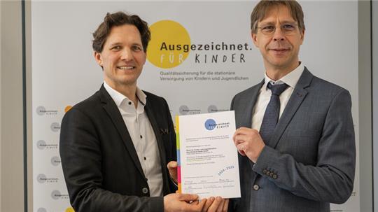 Schleswig-Holsteins Gesundheitsstaatssekretär Oliver Grundei (links) überreicht Chefarzt Dr. Markus Krüger das Zertifikat. Foto: Kommission Ausgezeichnet. Für Kinder.