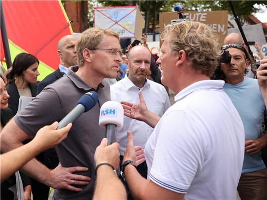 Schleswig-Holsteins Ministerpräsident Daniel Günther im Zwiegespräch mit Demonstranten auf Fehmarn. Foto: dpa