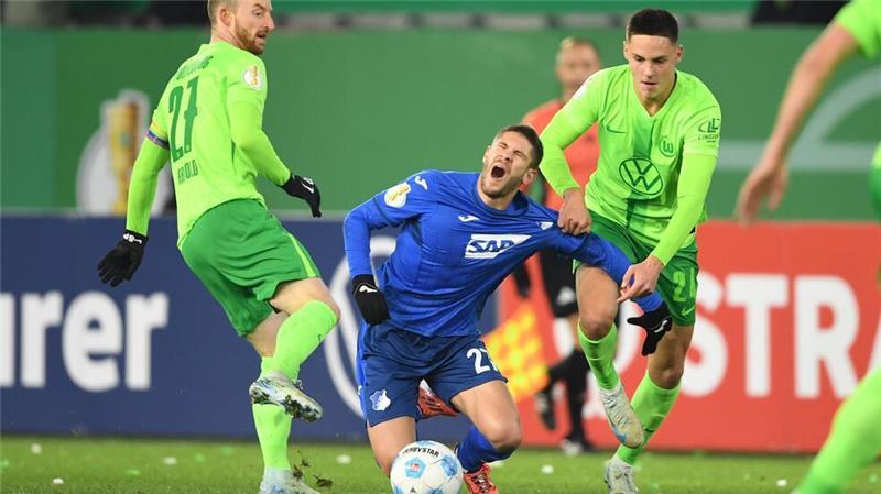Schmerzhaft: Die Wolfsburger Maximilian Arnold (l) und Joakim Maehle stoppen Hoffenheims Torjäger Andrej Kramaric.