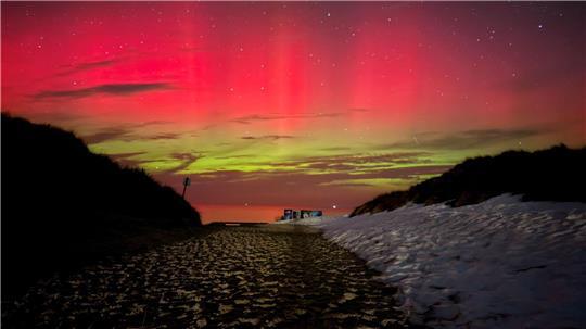 Schnee, Sand und bunte Lichter bilden einen seltenen Anblick auf der Nordseeinsel Norderney.