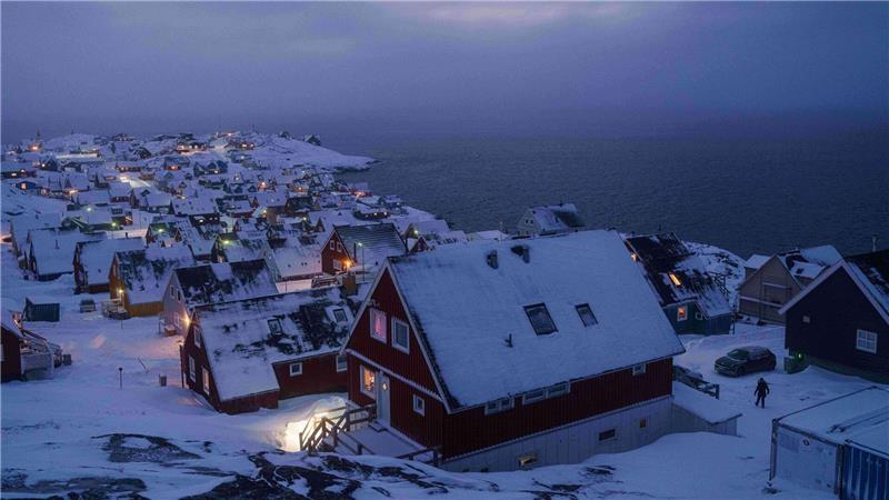 Schnee bedeckte Häuser stehen an der Küste einer Meeresbucht in Nuuk, der Hauptstadt von Grönland.