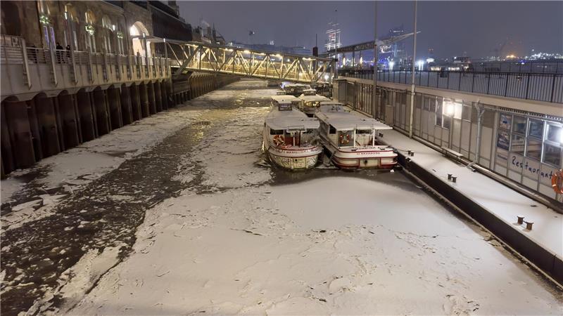 Schnee und Eis ist am späten Abend auf dem Wasser der Elbe in Hamburg zu sehen.