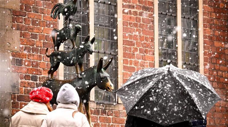 Schneeflocken tanzen um die Bremer Stadtmusikanten