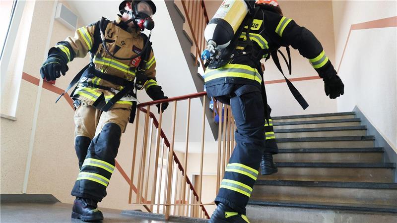 Schneller als die Feuerwehr: Feuerwehrmänner mit Atemschutzmasken und Sauerstoffflaschen rennen eine Treppe hoch beim Hochhaus-Treppenlauf und Feuerwehr-Treppenlauf in Zwickau.