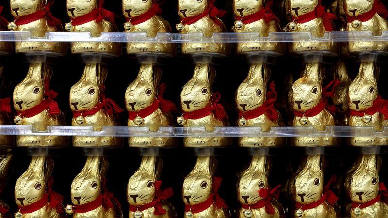 Schoko-Osterhasen stehen in einem Supermarkt im Regal.
