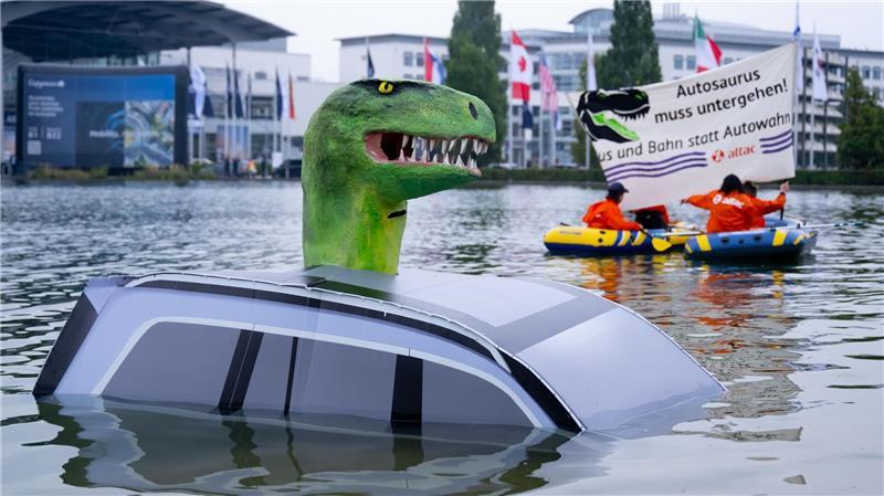 IAA: Schulterschluss gegen das Verbrennerverbot Schon vor der offiziellen Eröffnung protestierte Attac mit einem „Autosaurus“ am Münchner Messegelände.