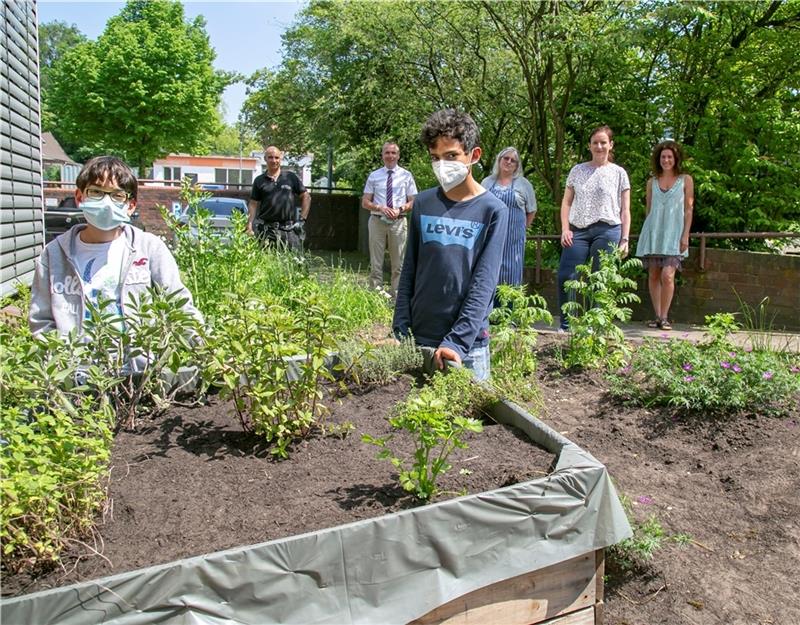Schüler bepflanzen die Hochbeete des Projekts Essbare Stadt. Im Hintergrund von links: Hausmeister Andreas Klemens, Athe-Leiter Martin Niestroj, Mensa-Leiterin Frauke Mencke, Kreisbaurätin Madeleine Pönitz und Initiatorin Yvonne Mayet. Foto
