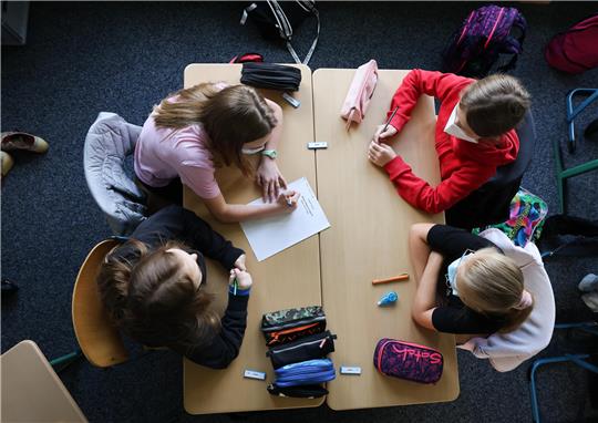 Schülerinnen und Schüler der Klasse 6a am Goethe-Gymnasium in Hamburg-Lurup schreiben in einer Gruppenarbeit im Klassenzimmer ihre Wünsche für das neue Schuljahr auf einen Zettel unter dem Motto: „Darauf freue ich mich?“ am ersten Schultag nach den Ferien. Foto: Christian Charisius/dpa