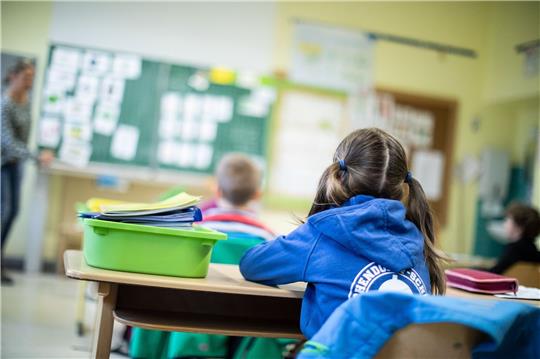 Schülerinnen und Schüler einer Grundschule sitzen in ihrem Klassenraum.