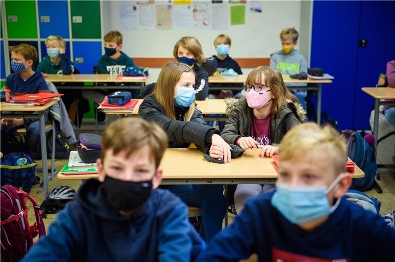 Schülerinnen und Schüler einer sechsten Klasse mit Alltagsmasken im Klassenzimmer. Foto: Gregor Fischer/dpa