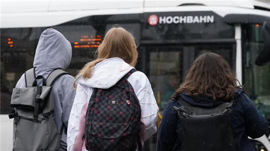 Schülerinnen und Schüler steigen in einen Bus.