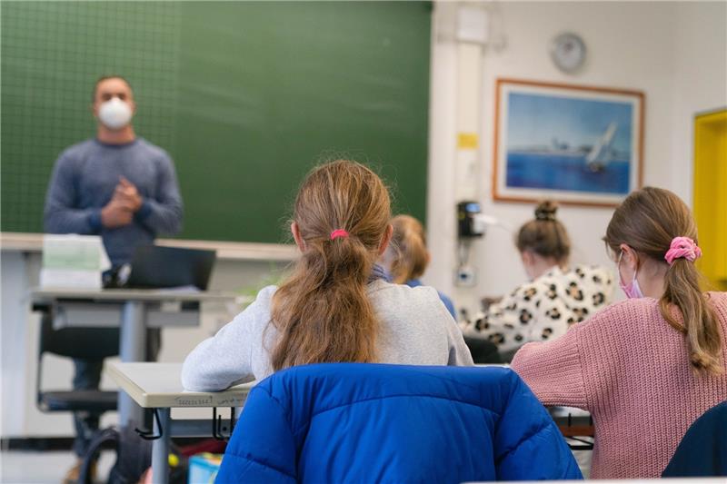 Schülerinnen und Schüler einer fünften Klasse im Unterricht im Klassenzimmer. Es herrscht Maskenpflicht. Foto: Nicolas Armer/dpa